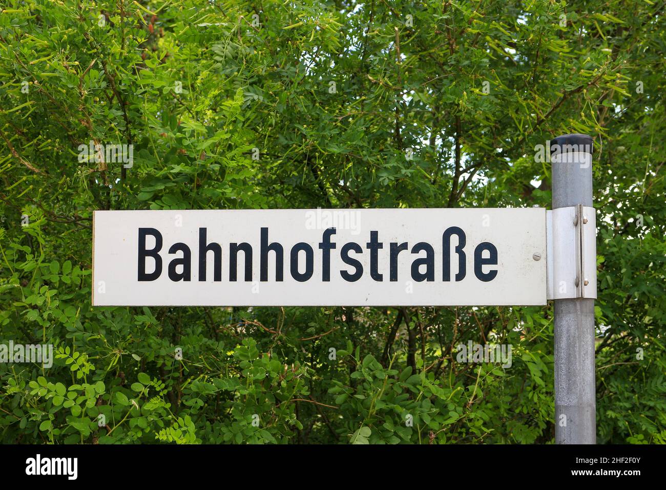Il segnale stradale tedesco si traduce in via della stazione ferroviaria in inglese Foto Stock