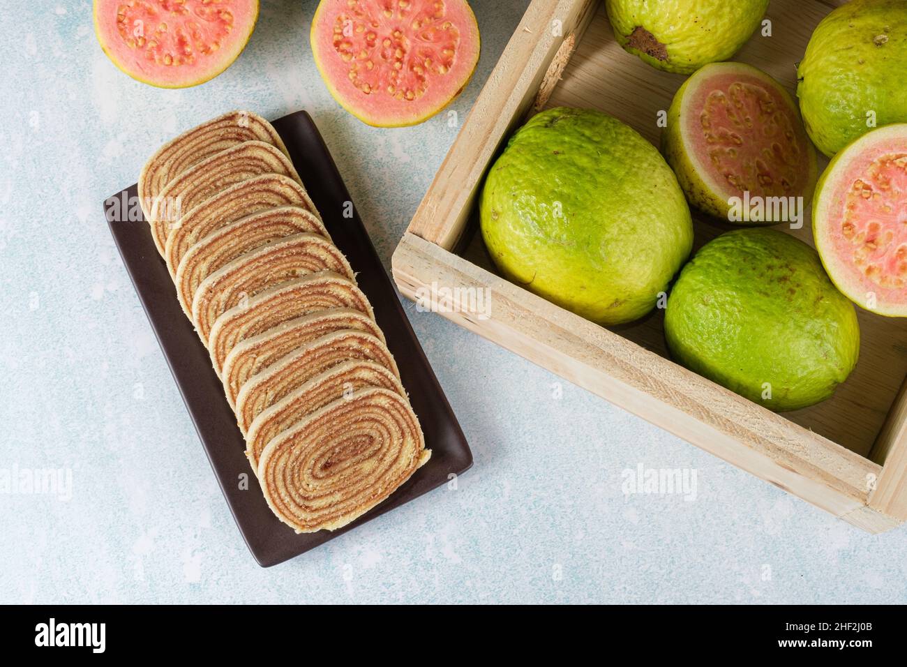 Bolo de rolo affettato accanto ad una scatola con guavas (vista dall'alto). Foto Stock