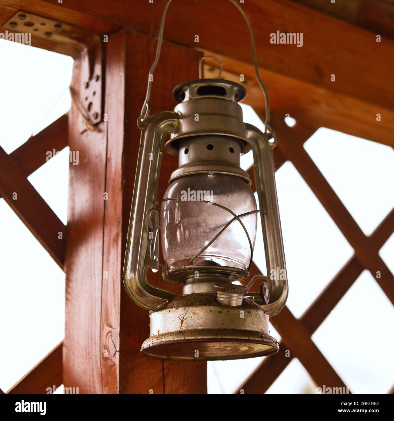 Lanterna ad olio di cherosene vintage appesa su colonna di legno. Vecchia  lampada retrò antica Foto stock - Alamy