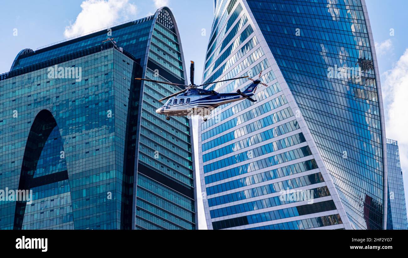 MOSCA, RUSSIA - 7 MAGGIO 2021: L'elicottero vola sullo sfondo dei grattacieli di Mosca Foto Stock