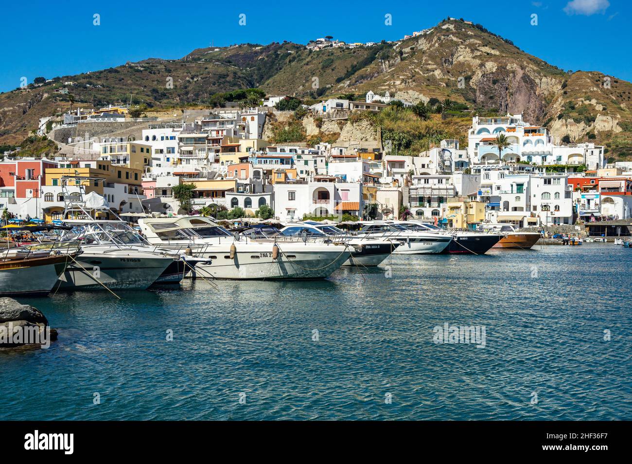 Barche da pesca e motoscafi ormeggiati nel colorato porto di Sant’Angelo d’Ischia Foto Stock