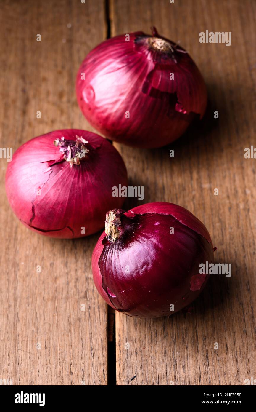 Cipolle appena raccolte di diversi tipi e dimensioni su un tavolo di legno. Foto di alta qualità Foto Stock