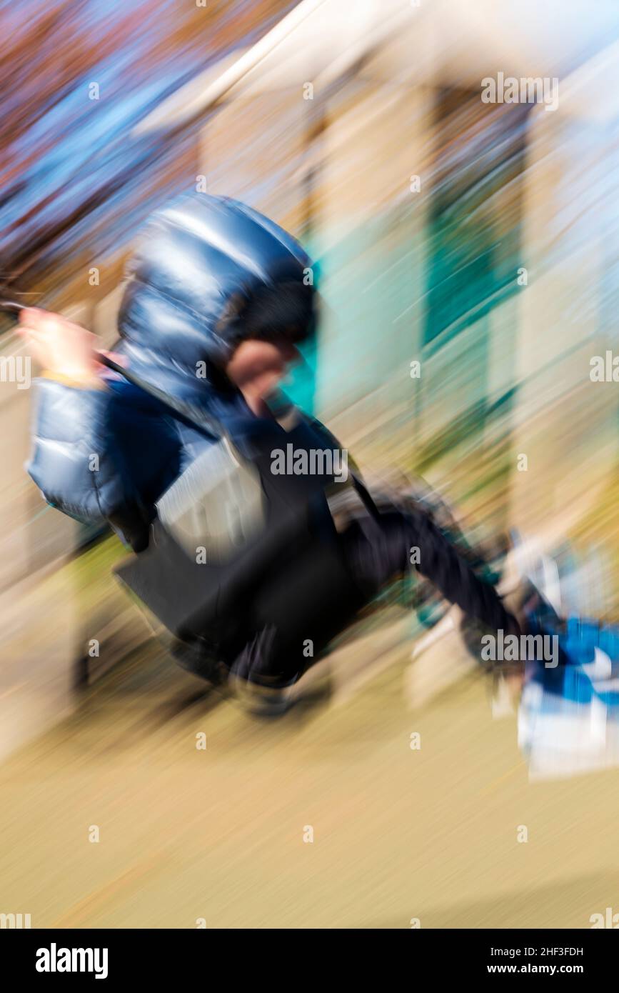 Blur - Pan - foto d'azione di un ragazzo di due anni che oscilla sul parco cittadino; Corinthian Gardens; Philadelphia; Pennsylvania; USA Foto Stock