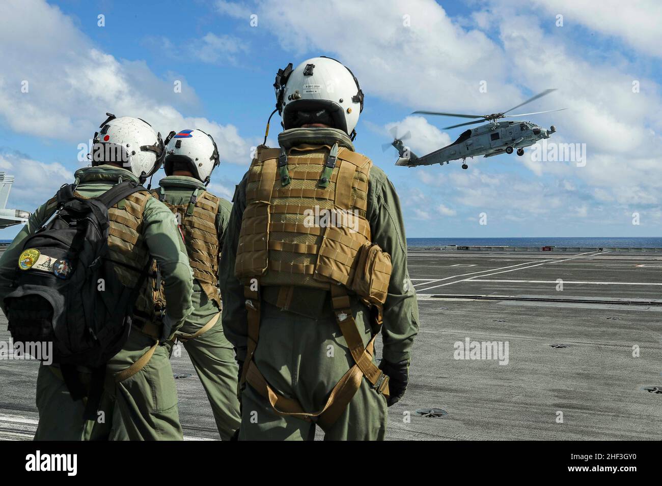 OCEANO PACIFICO (Gen. 11, 2022) i marinai si rinforzano come un elicottero MH-60R Sea Hawk, assegnato ai 'Raptors' di Helicopter Maritime Strike Squadron (HSM) 71, atterra sul ponte di volo di USS Abraham Lincoln (CVN 72). Il Abraham Lincoln Carrier Strike Group, guidato dal Carrier Strike Group 3, è stato dispiegato da San Diego, gennaio 3, a sostegno delle operazioni di sicurezza marittima globale. Parte integrante della U.S. Pacific Fleet, la U.S. 3rd Fleet gestisce le forze navali nell'Indo-Pacific e fornisce la formazione realistica e pertinente necessaria per svolgere il ruolo della nostra Marina in tutta la gamma di truppe militari Foto Stock