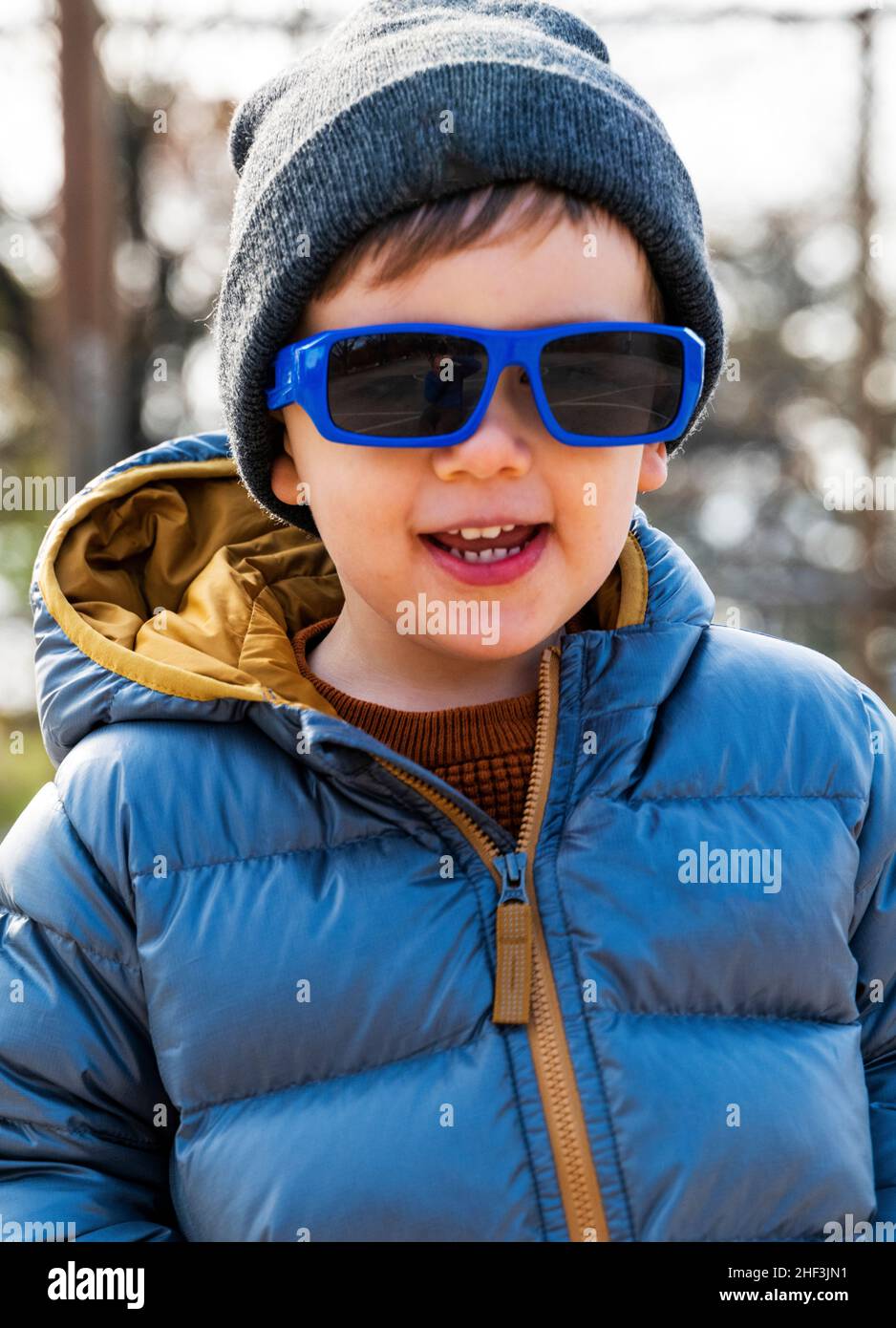 Ragazzo di due anni con occhiali da sole in esecuzione sul parco giochi della città; Corinthian Gardens; Philadelphia; Pennsylvania; USA Foto Stock