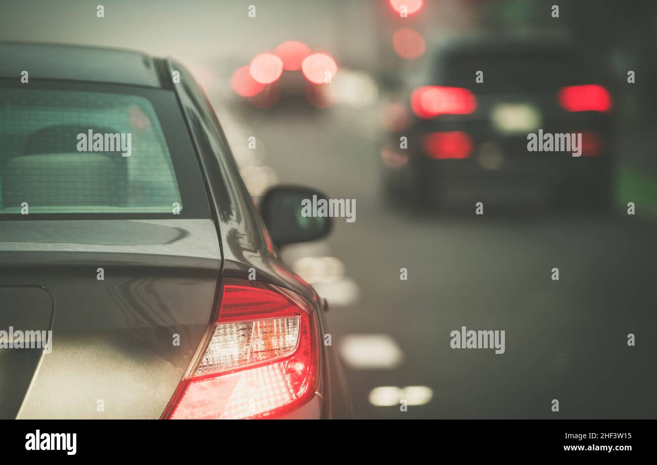 Big City Commuter Cars durante le ore di corsa Foggy Condizioni meteorologiche. Tema traffico cittadino moderno. Foto Stock