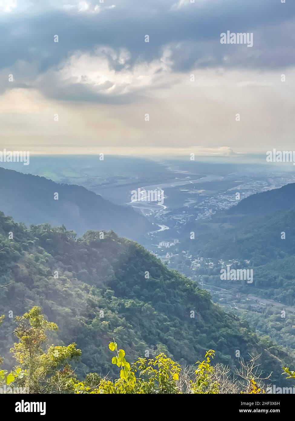 Una vista aperta vasta valle di montagna con erba secca e cielo nuvoloso Foto Stock