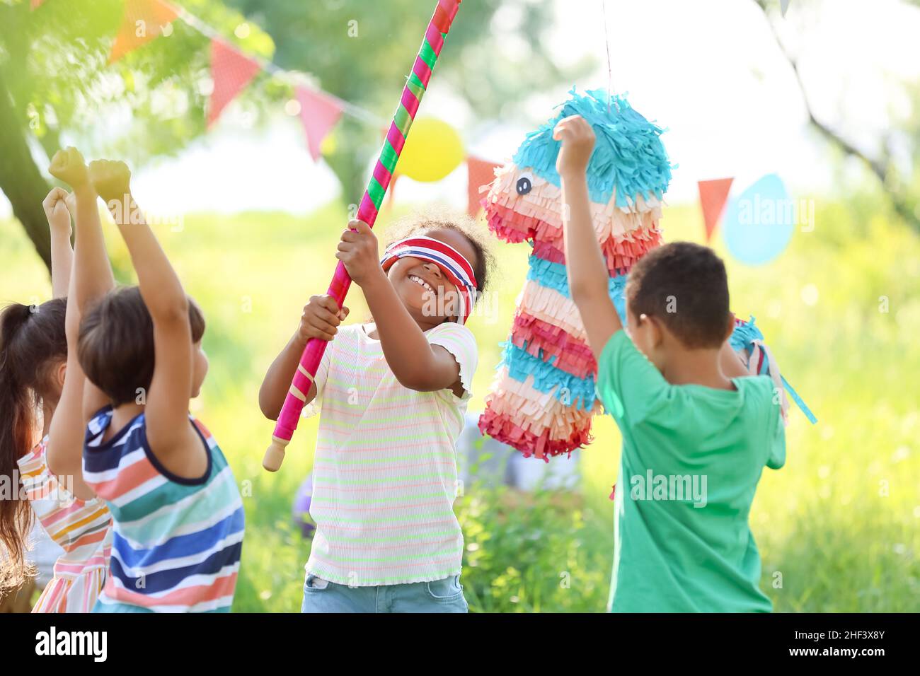 Kids festa di compleanno. Gruppo di bambini colpendo pinata e giocare con i  palloncini. Famiglia con bambini festeggia il compleanno in giardino Foto  stock - Alamy