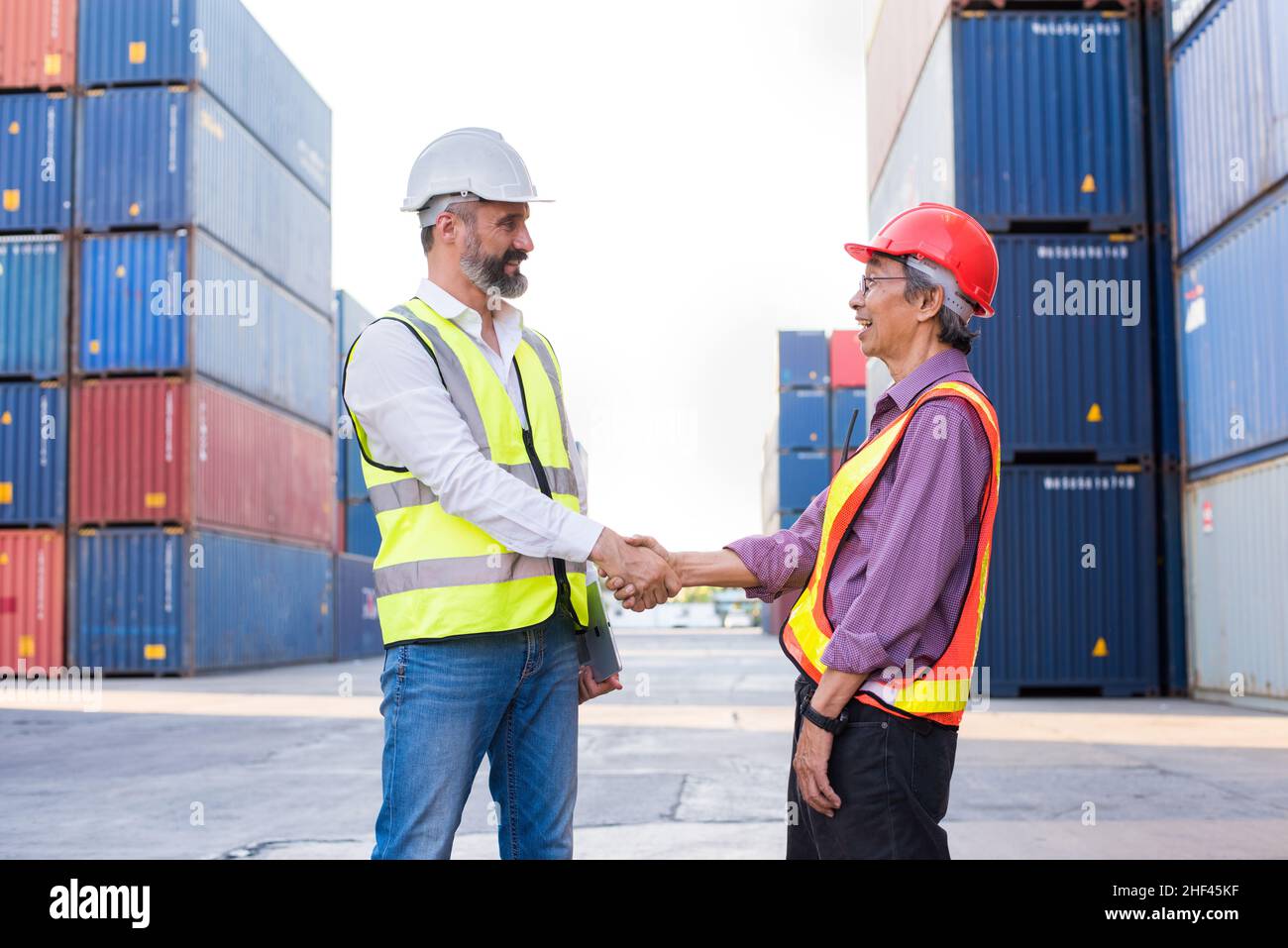 L'ingegnere capo controlla il caricamento della scatola dei contenitori dalla nave di trasporto del carico per l'esportazione di importazione. Container per il trasporto in mare. Foto Stock