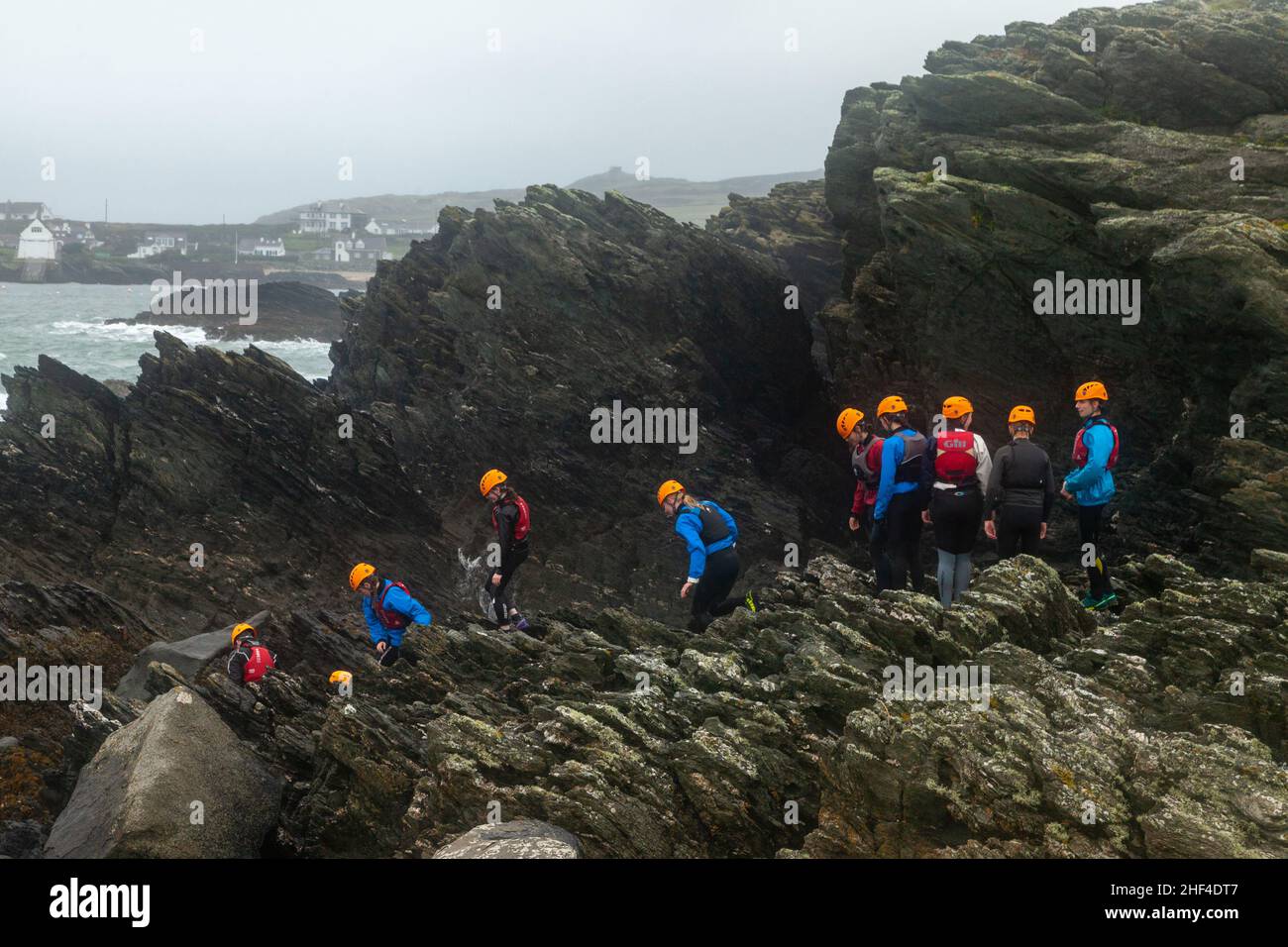 I bambini delle scuole si dirigano verso il governo coastering in Anglesey, Galles del Nord. Foto Stock