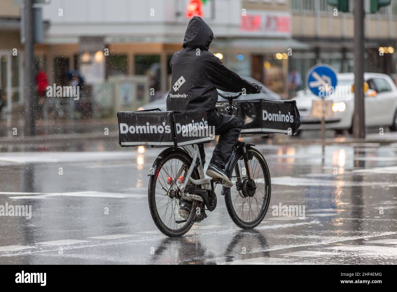 Domino's Pizza conducente di consegna in bicicletta sotto la pioggia Foto Stock