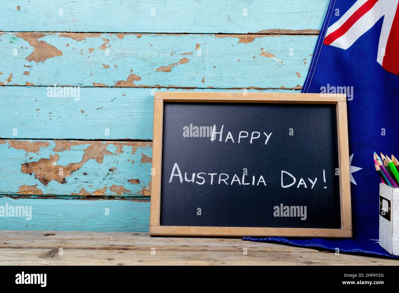 Felice australia giorno testo sulla scrittura ardesia da bandiera nazionale contro muro di legno con spazio copia Foto Stock