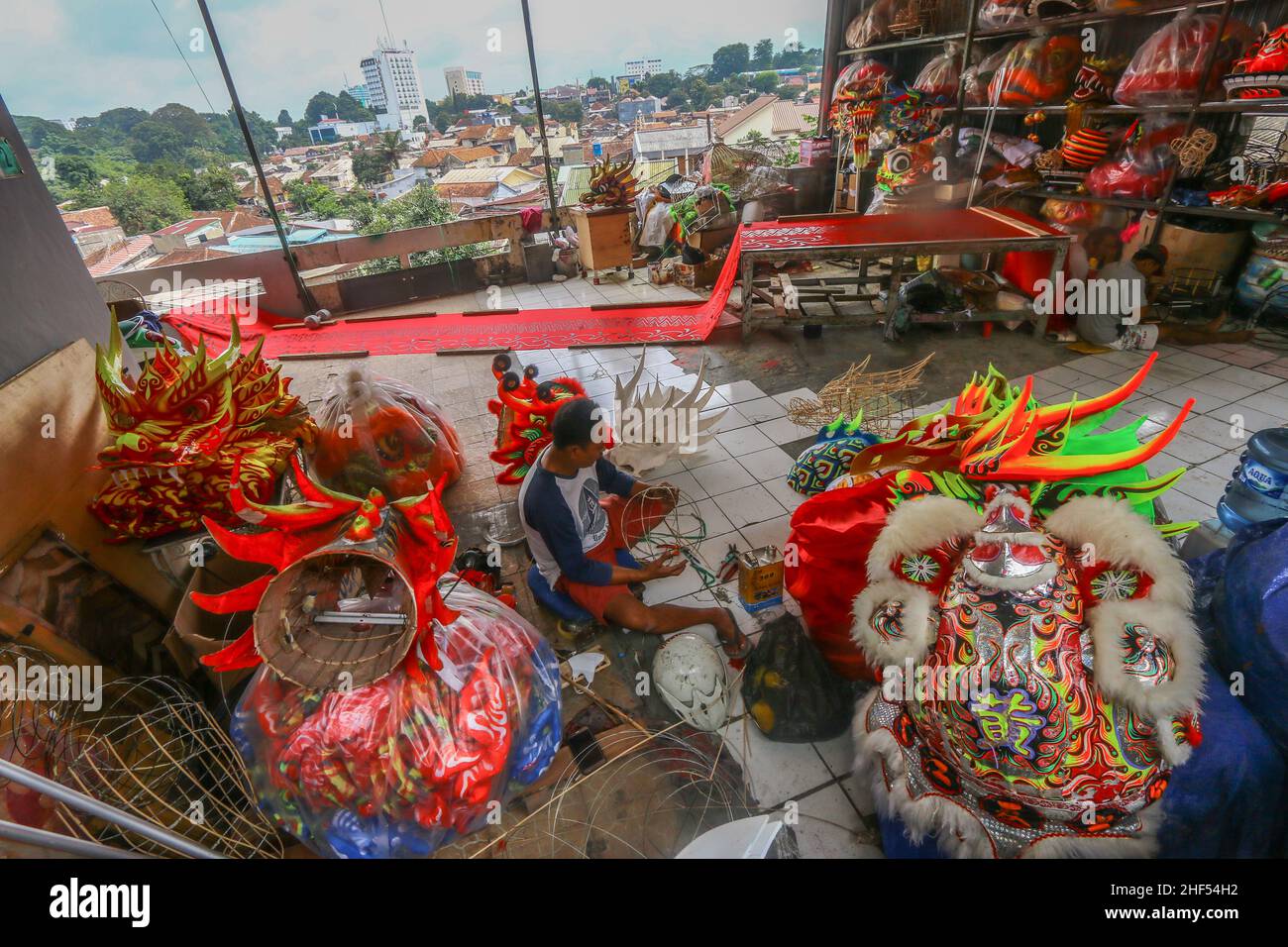 Un artigiano creatore di costumi da ballo leone (Barongsai) e drago (Liong), ispeziona le sue creazioni all'interno della sua casa prima delle celebrazioni del Capodanno lunare Foto Stock