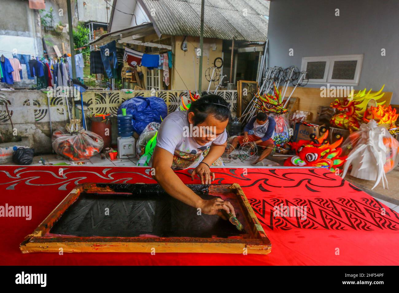 Un artigiano creatore di costumi da ballo leone (Barongsai) e drago (Liong), ispeziona le sue creazioni all'interno della sua casa prima delle celebrazioni del Capodanno lunare Foto Stock