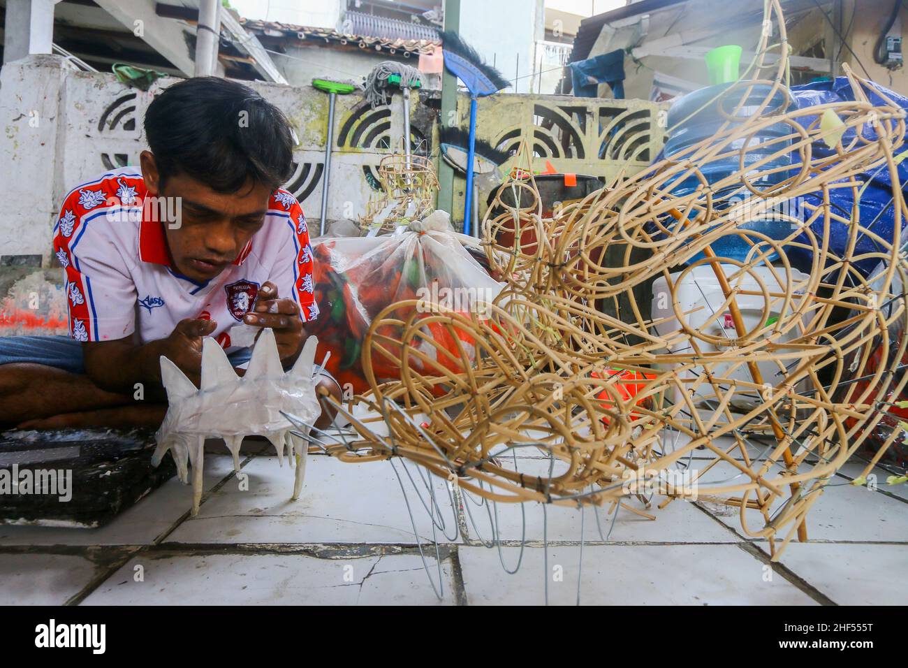 Un artigiano creatore di costumi da ballo leone (Barongsai) e drago (Liong), ispeziona le sue creazioni all'interno della sua casa prima delle celebrazioni del Capodanno lunare Foto Stock