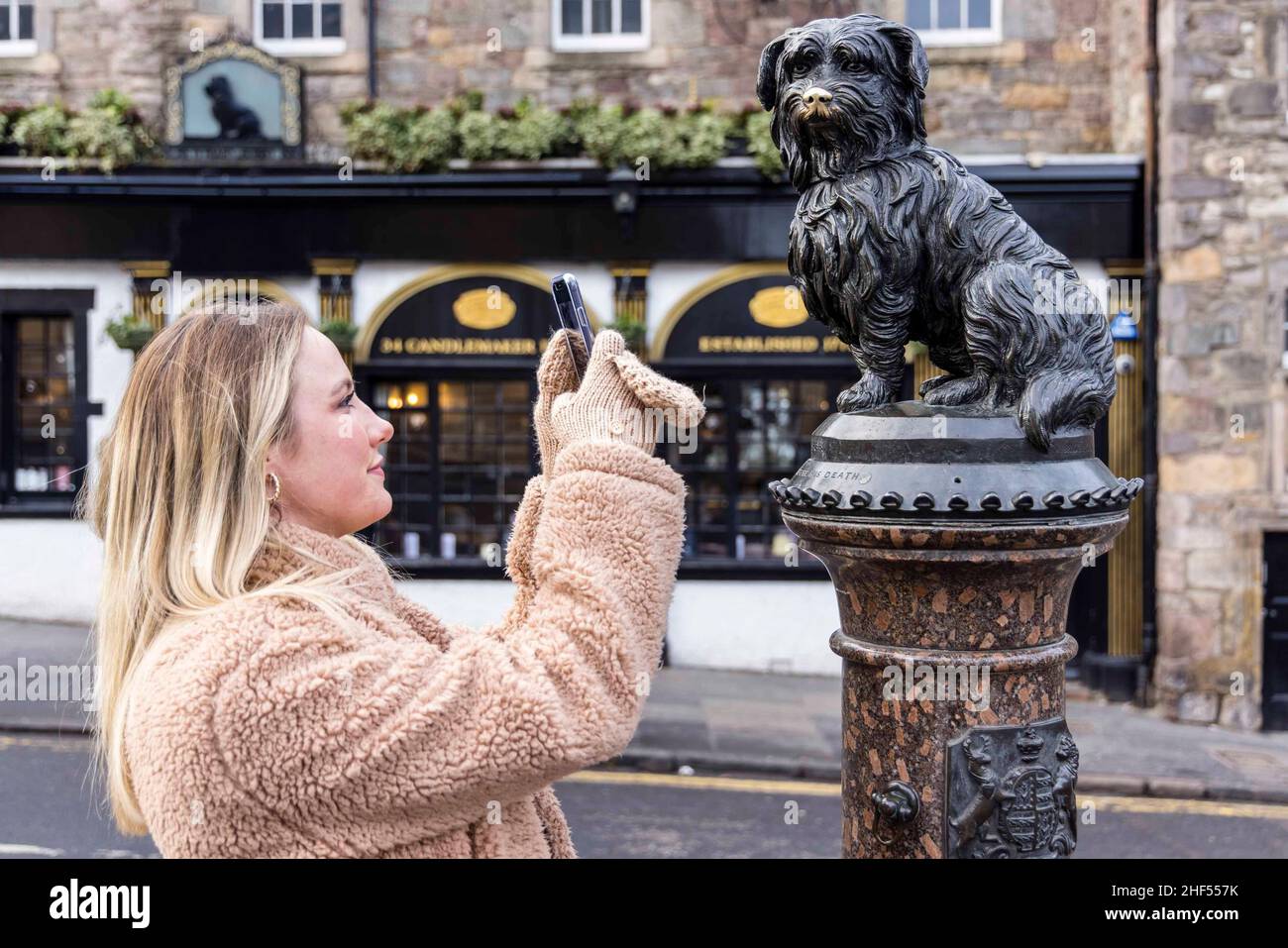 Edimburgo, Regno Unito. 14th Jan 2022. Nella foto: Da L a R Megan Moen fotografa l'iconica statua di Bobby dei Greyfriars. Il 14 gennaio segna il 150th anniversario della morte del lSkye Terrier noto come Greyfrars Bobby. La leggenda è che il cane ha trascorso 14 anni a custodire la tomba del suo proprietario, John Gray, un uomo di polizia di Edimburgo e Nightwatchman. Credit: Rich Dyson/Alamy Live News Foto Stock