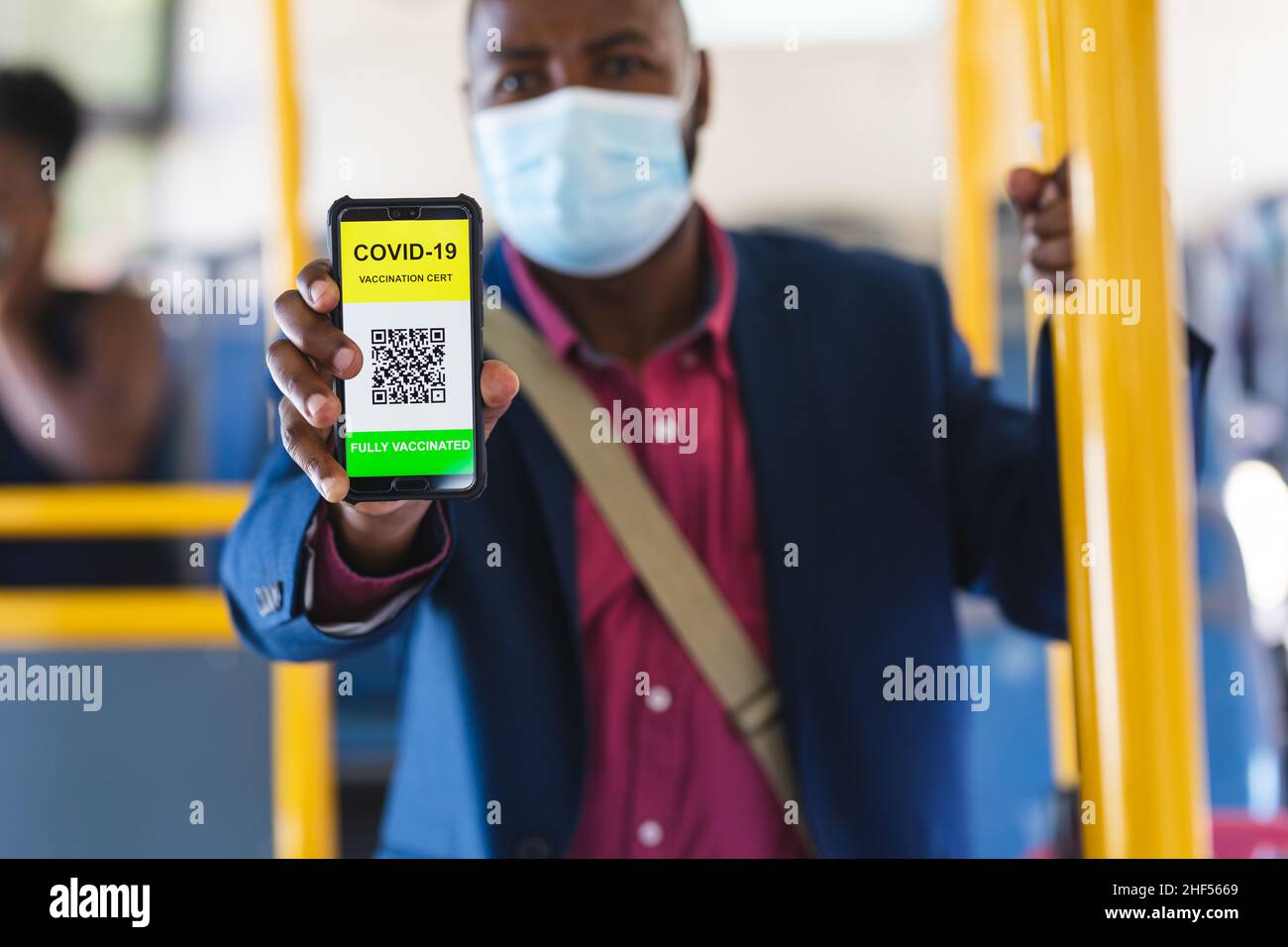 Uomo d'affari con certificato di vaccinazione covid-19 sul suo schermo dello smartphone durante il viaggio in ufficio Foto Stock