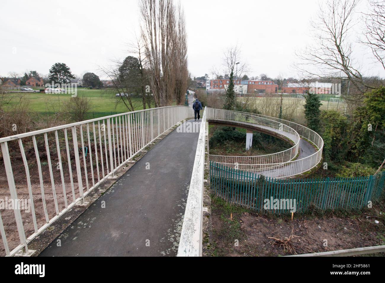 L'inusuale ponte pedonale che attraversa il principale A5 in Atherstone. Chiamato dalla gente del posto come il ponte di curly wurley a causa del suo design, il ponte porta gli escursionisti dalla tenuta industriale di Carolyn lungo Well Spring Close, sopra la doppia autostrada A5 e sulla Witherley Road accanto alla High School. Spesso utilizzato come scorciatoia da alunni e lavoratori, il ponte dovrebbe essere demolito nel 2022 in quanto è stato considerato pericoloso. Un nuovo ponte è previsto per prendere il suo posto che finisce oltre mezzo secolo di utilizzo. Foto Stock
