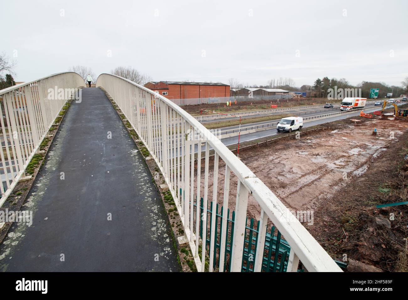 L'inusuale ponte pedonale che attraversa il principale A5 in Atherstone. Chiamato dalla gente del posto come il ponte di curly wurley a causa del suo design, il ponte porta gli escursionisti dalla tenuta industriale di Carolyn lungo Well Spring Close, sopra la doppia autostrada A5 e sulla Witherley Road accanto alla High School. Spesso utilizzato come scorciatoia da alunni e lavoratori, il ponte dovrebbe essere demolito nel 2022 in quanto è stato considerato pericoloso. Un nuovo ponte è previsto per prendere il suo posto che finisce oltre mezzo secolo di utilizzo. Foto Stock