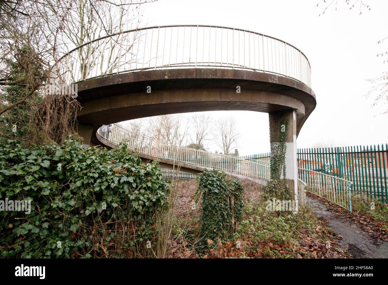 L'inusuale ponte pedonale che attraversa il principale A5 in Atherstone. Chiamato dalla gente del posto come il ponte di curly wurley a causa del suo design, il ponte porta gli escursionisti dalla tenuta industriale di Carolyn lungo Well Spring Close, sopra la doppia autostrada A5 e sulla Witherley Road accanto alla High School. Spesso utilizzato come scorciatoia da alunni e lavoratori, il ponte dovrebbe essere demolito nel 2022 in quanto è stato considerato pericoloso. Un nuovo ponte è previsto per prendere il suo posto che finisce oltre mezzo secolo di utilizzo. Foto Stock