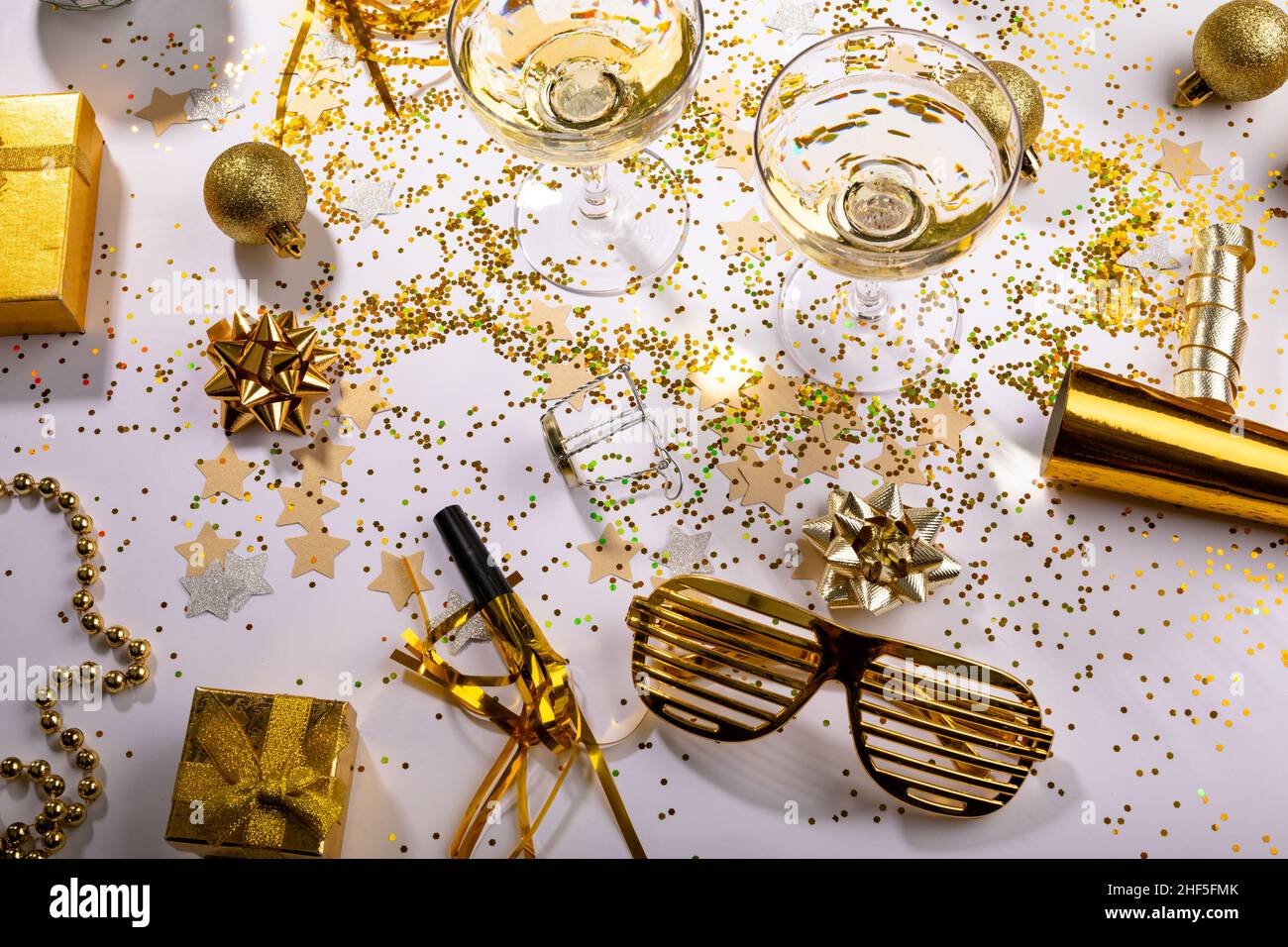 Bicchieri di champagne con decorazione color oro e scatole regalo sul tavolo, spazio copia Foto Stock