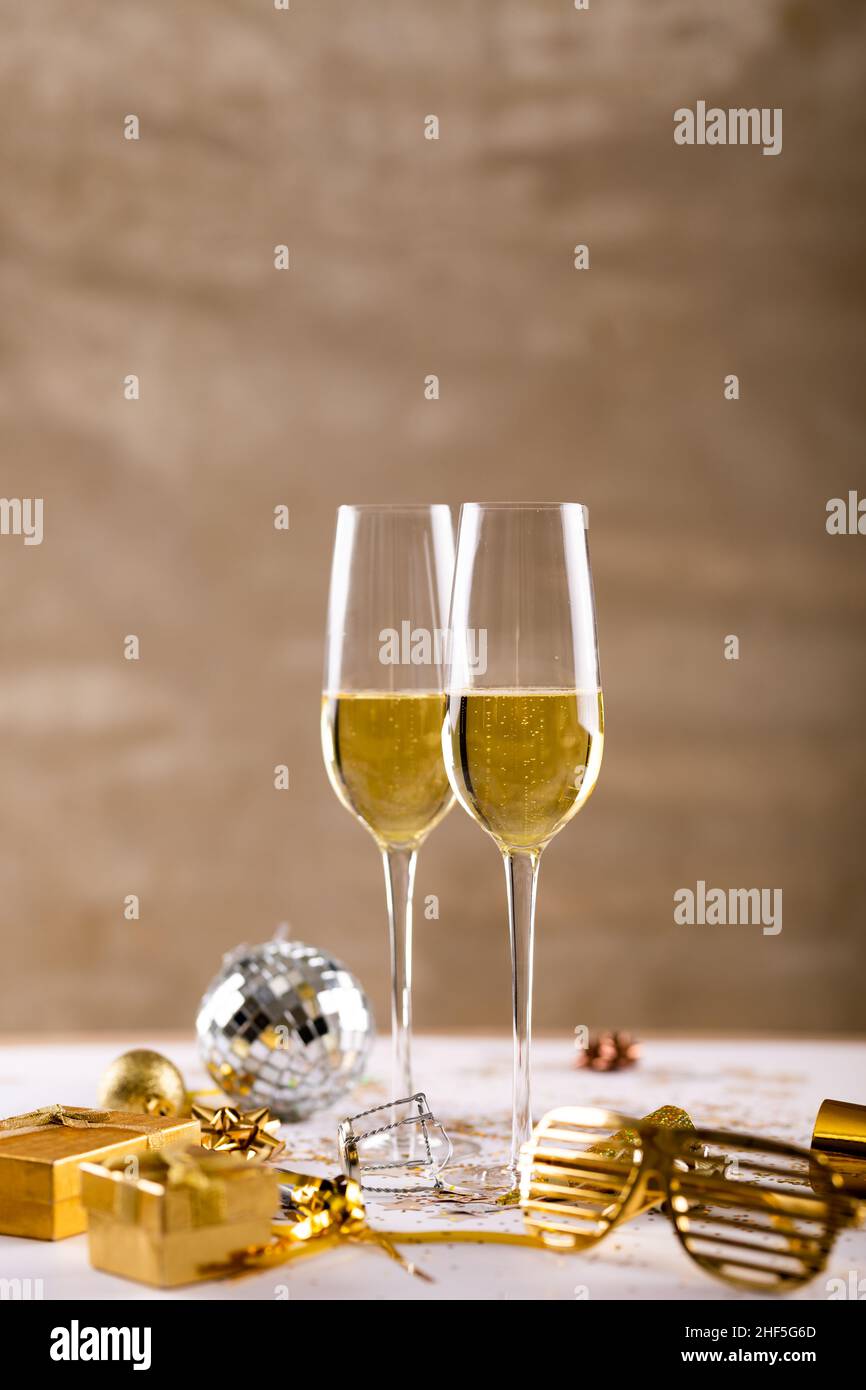 Primo piano di flute di champagne da bicchieri di novità dorati e scatole regalo sul tavolo Foto Stock
