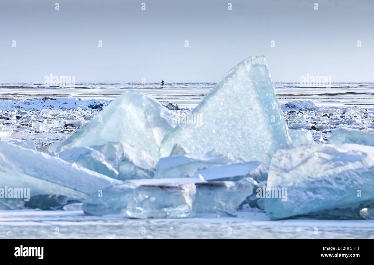 Uomo in giacca rossa giro in bici grasso a ghiacci ghiacciati triangolo al lago con neve in Kazakhstan Asia centrale Foto Stock