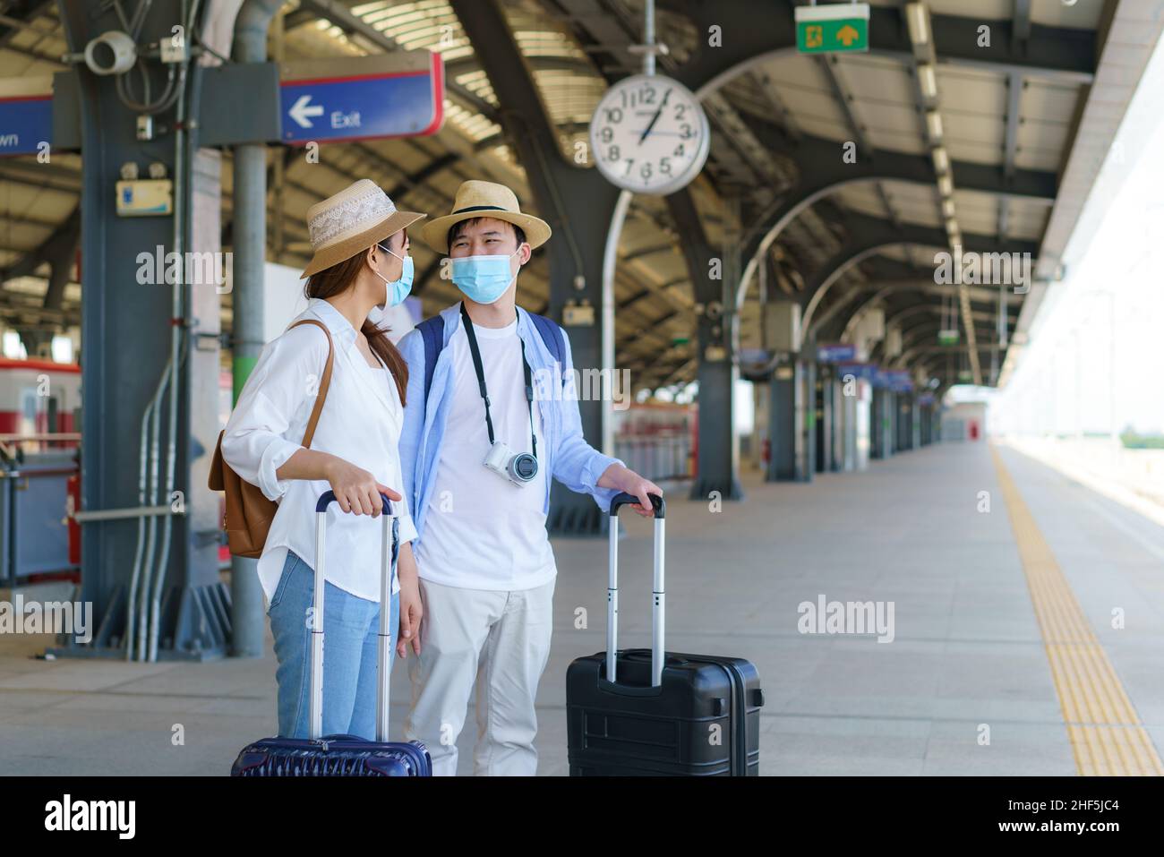 Coppia di viaggiatori asiatici in attesa treno alla stazione ferroviaria di Bangkok, Thailandia, concetto di viaggio e trasporto Foto Stock
