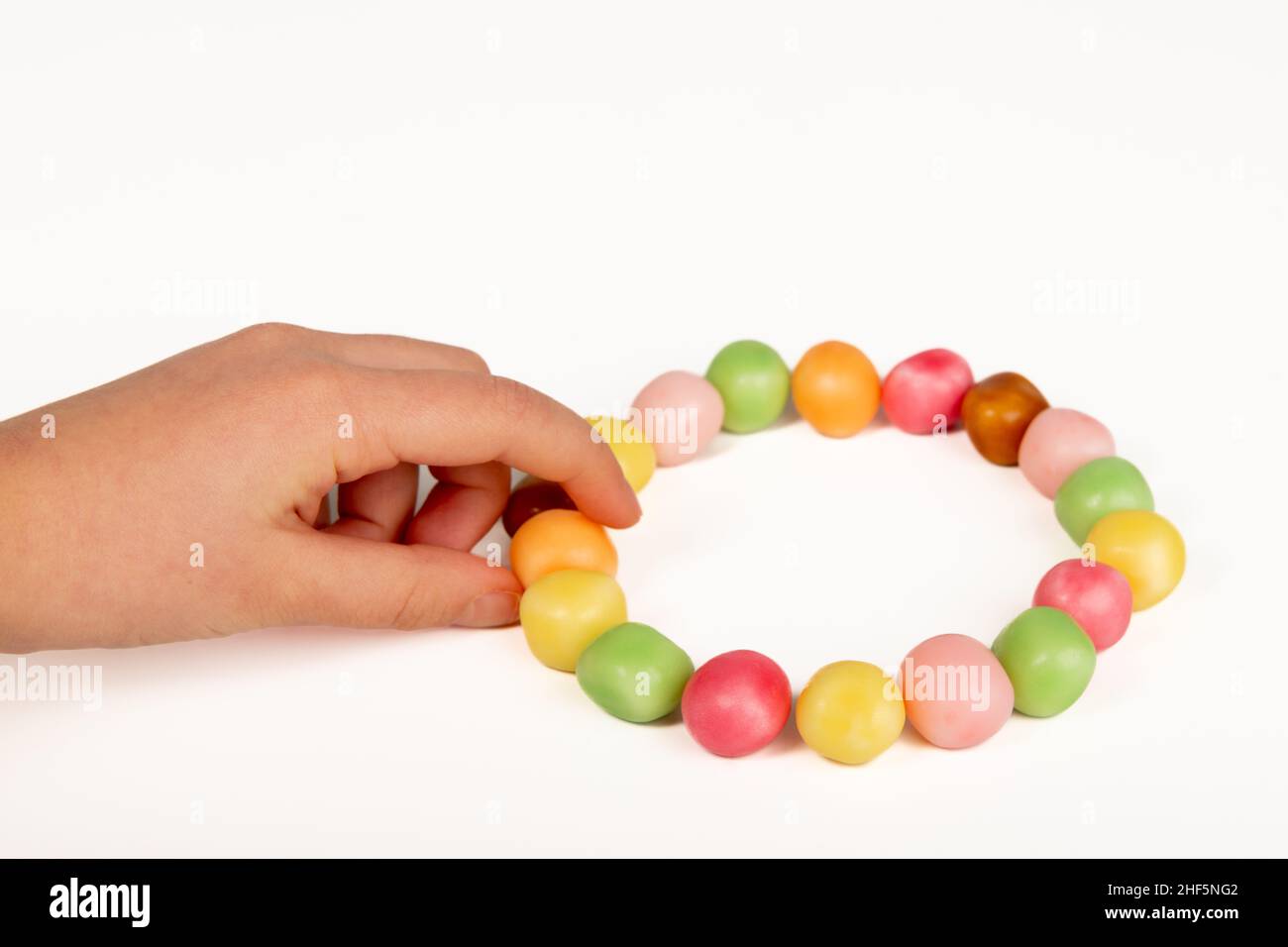 Bambino che prende una caramella su uno sfondo bianco Foto Stock