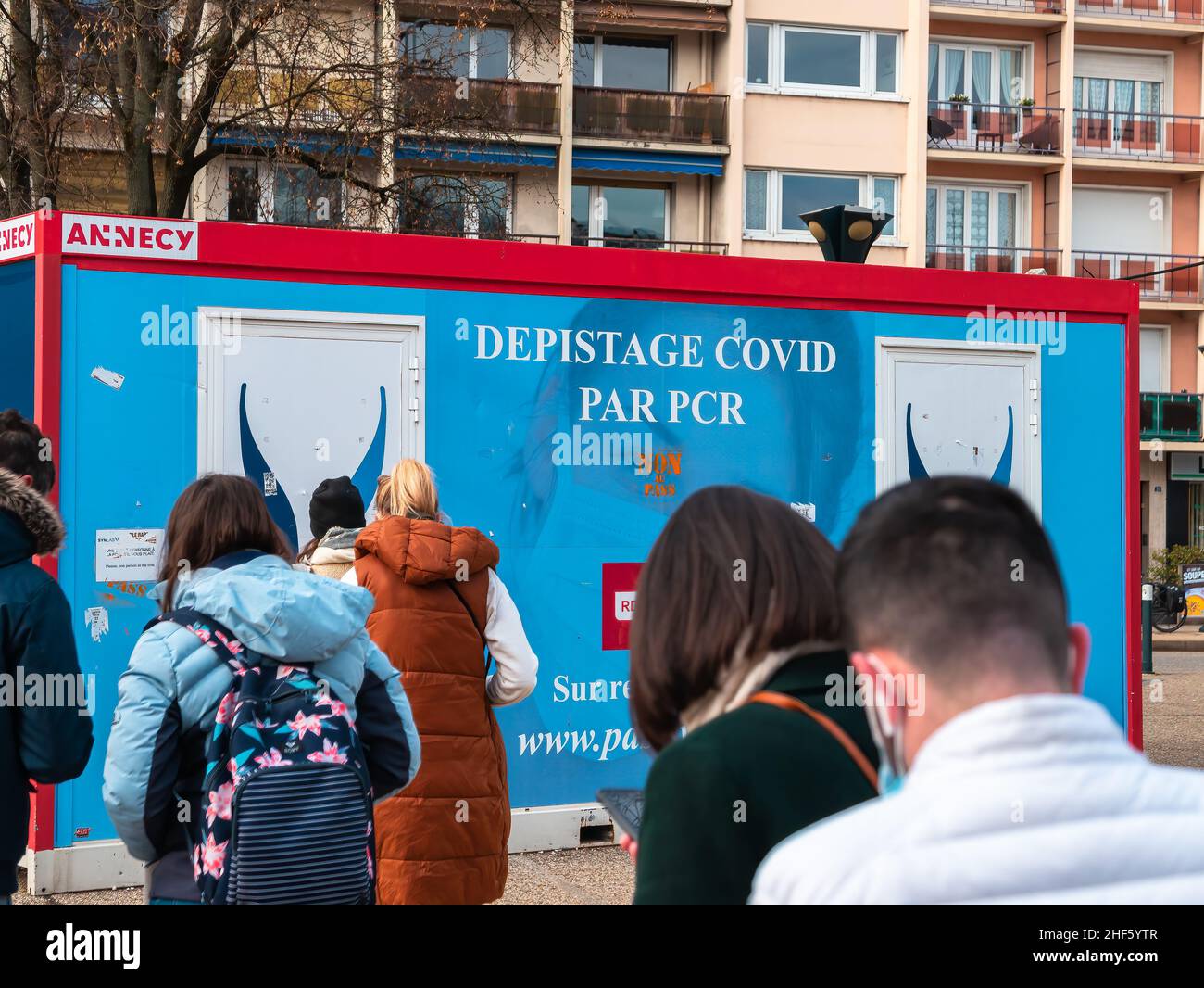 Annecy, Francia - 7 gennaio 2022: Un gruppo di giovani è in attesa di test PCR di fronte al covid-19 mobile unità di strada di Annecy Foto Stock