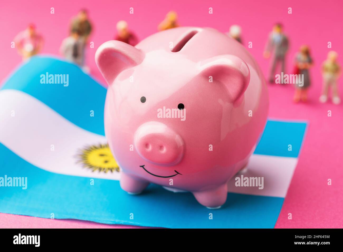 Piggy banca, bandiera argentina e giocattoli di plastica uomini su uno  sfondo colorato, concetto sul tema del reddito della popolazione argentina  Foto stock - Alamy