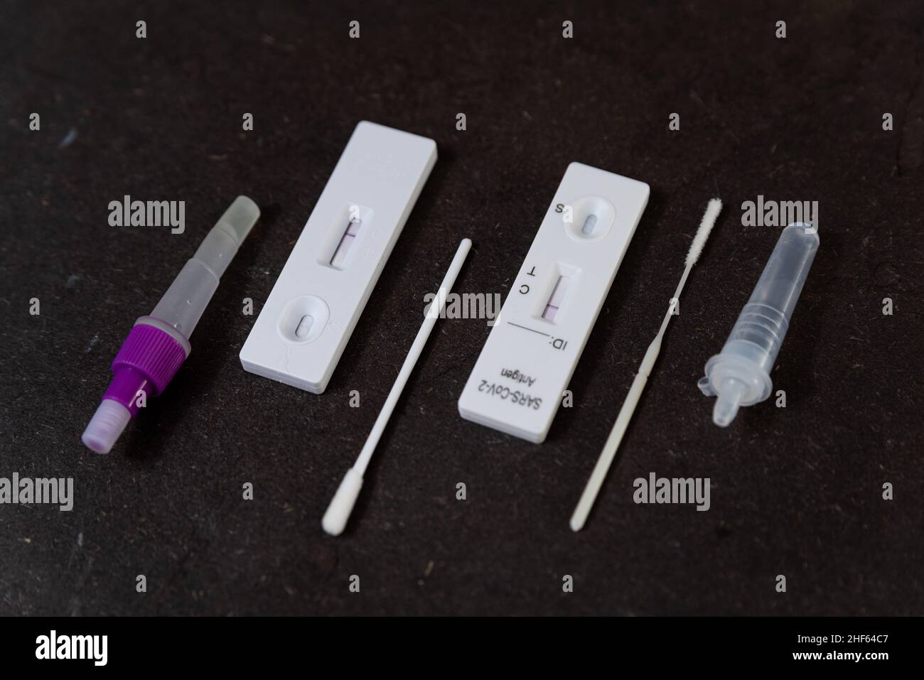 Un test rapido dell'antigene per SARS-COV-2 o Covid è osservato su una tabella con bastoncino da tampone nasale durante un rapido aumento della domanda dovuto alla variante Omicron di Cov Foto Stock