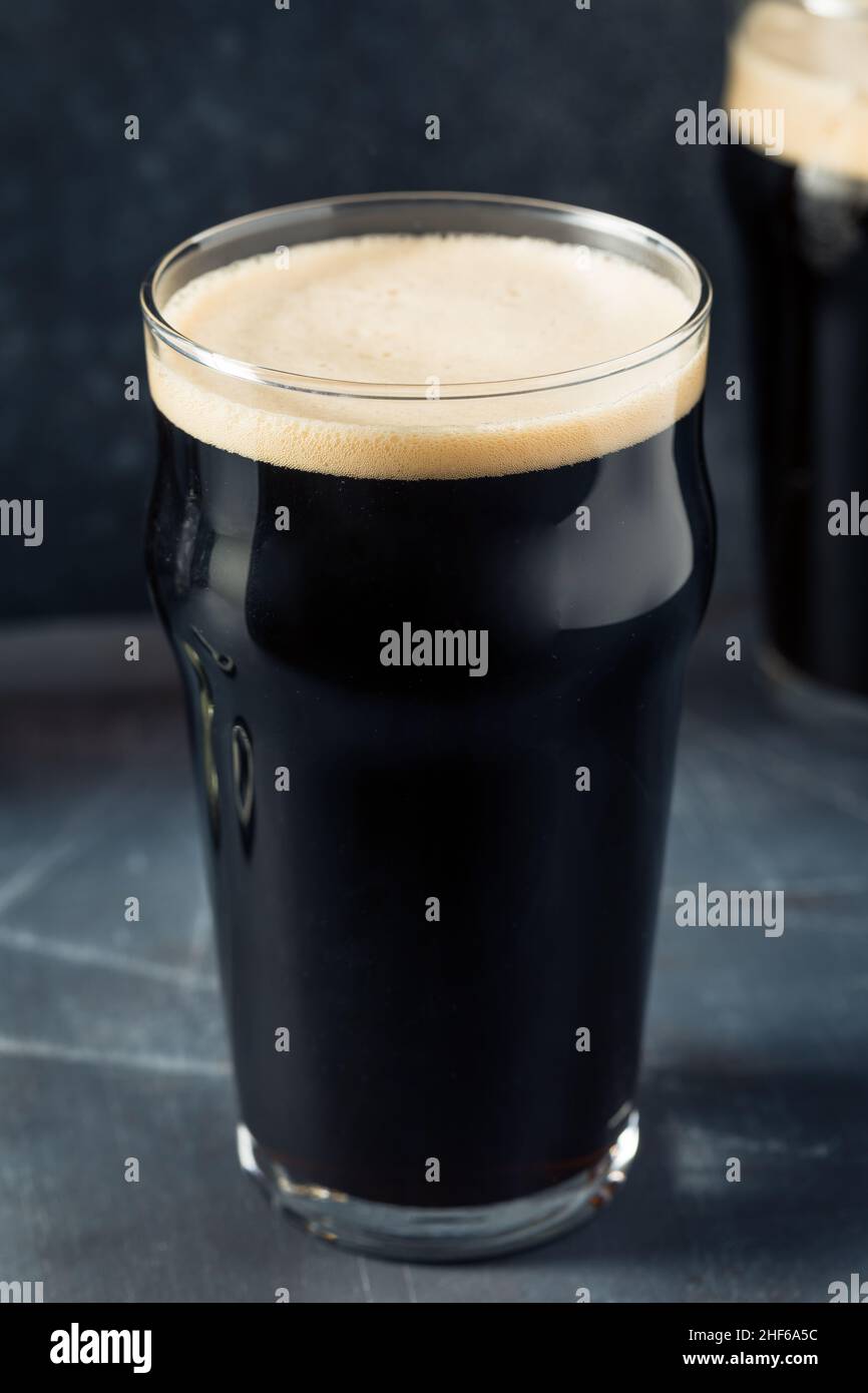 Rinfrescante birra Irish Stout fredda in un bicchiere di pinta Foto Stock