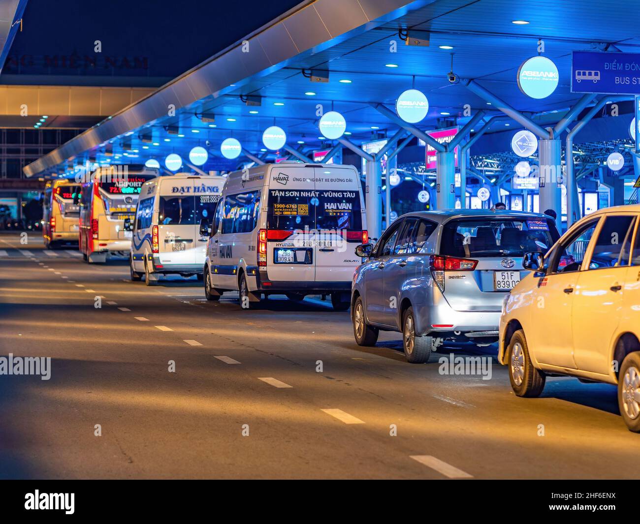 Taxi e autobus in attesa di notte per i passeggeri in arrivo al terminal nazionale dell'aeroporto internazionale Tan Son Nhat a ho Chi Minh City, Vietnam. Foto Stock