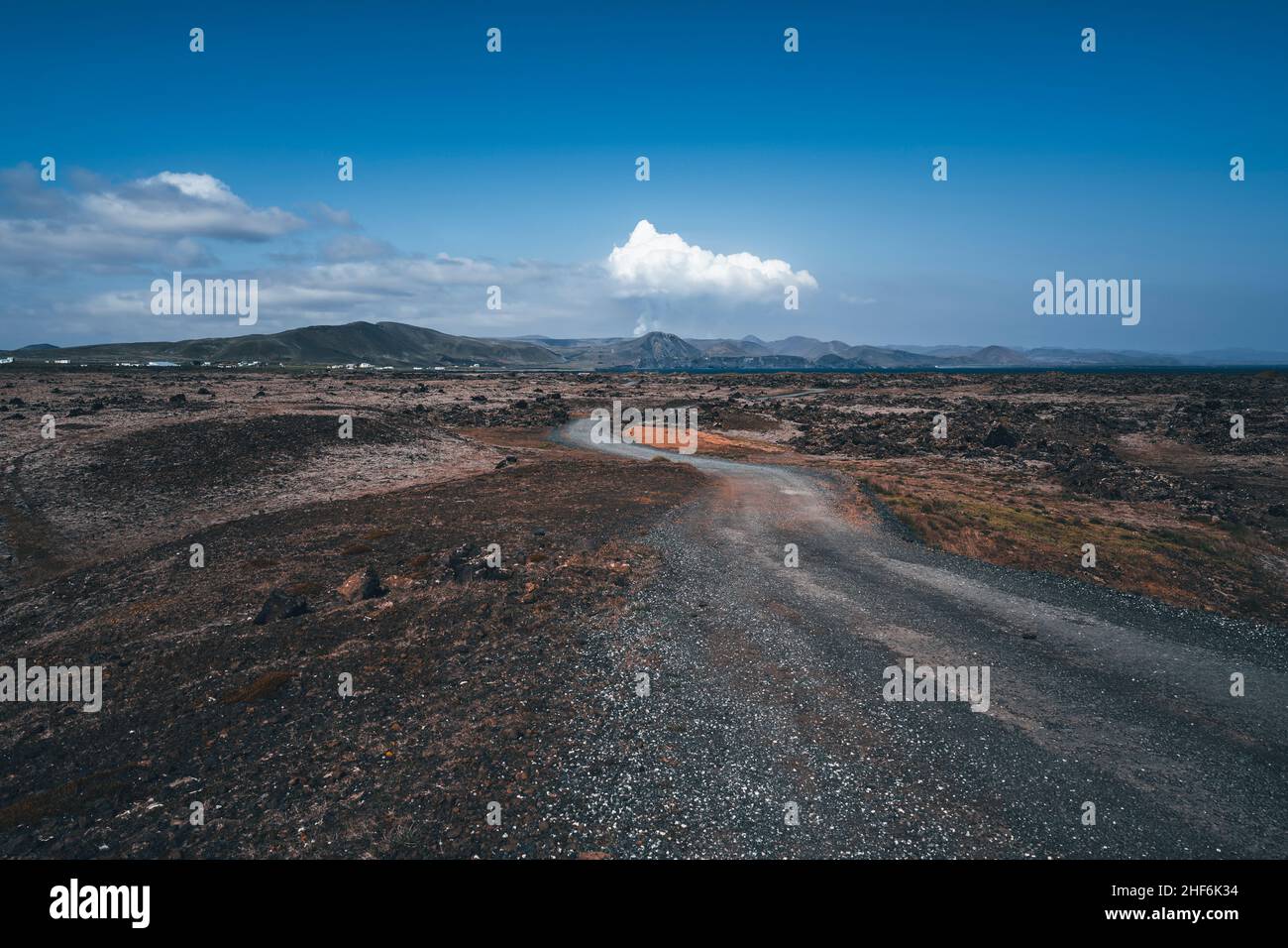 Strada con vulcano attivo sullo sfondo, Hópsnesviti, Islanda Foto Stock