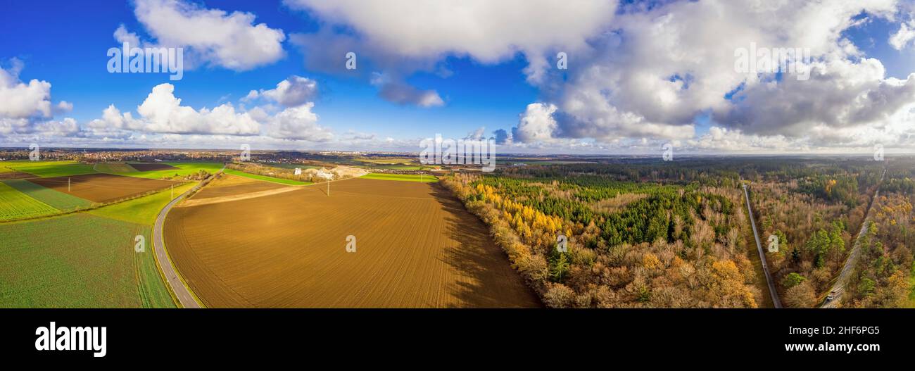 Paesaggio autunnale da una vista aerea. Cielo blu con nuvole puffy e campi d'autunno di colore arancione con una strada Foto Stock