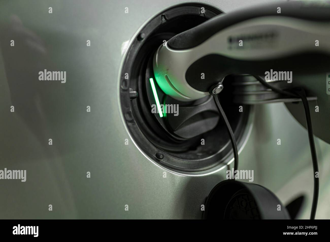 Facciamo ricaricare l'auto elettrica. Vista dei dettagli sulla spina di ricarica sul tappo del serbatoio dell'e-Automobiles Foto Stock