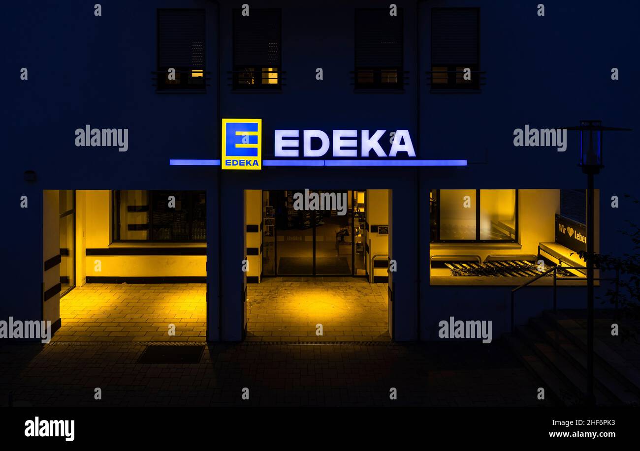 Supermercato Edeka nel 08041 Oberhaching, Hubertusstrasse 1, Germania al 19th agosto 2021 caputured nell'ora blu a metà 8 con il suo logo EDEKA illuminato e l'ingresso al mercato Foto Stock