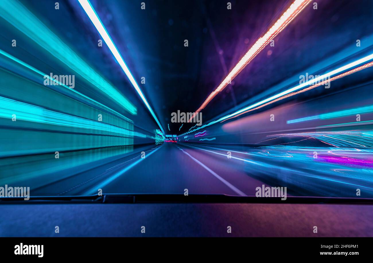 Guida sotterranea ad alta velocità - concetto colorato per le corse durante la notte e sorpassa un'altra auto in un tunnel con effetto motion blur Foto Stock