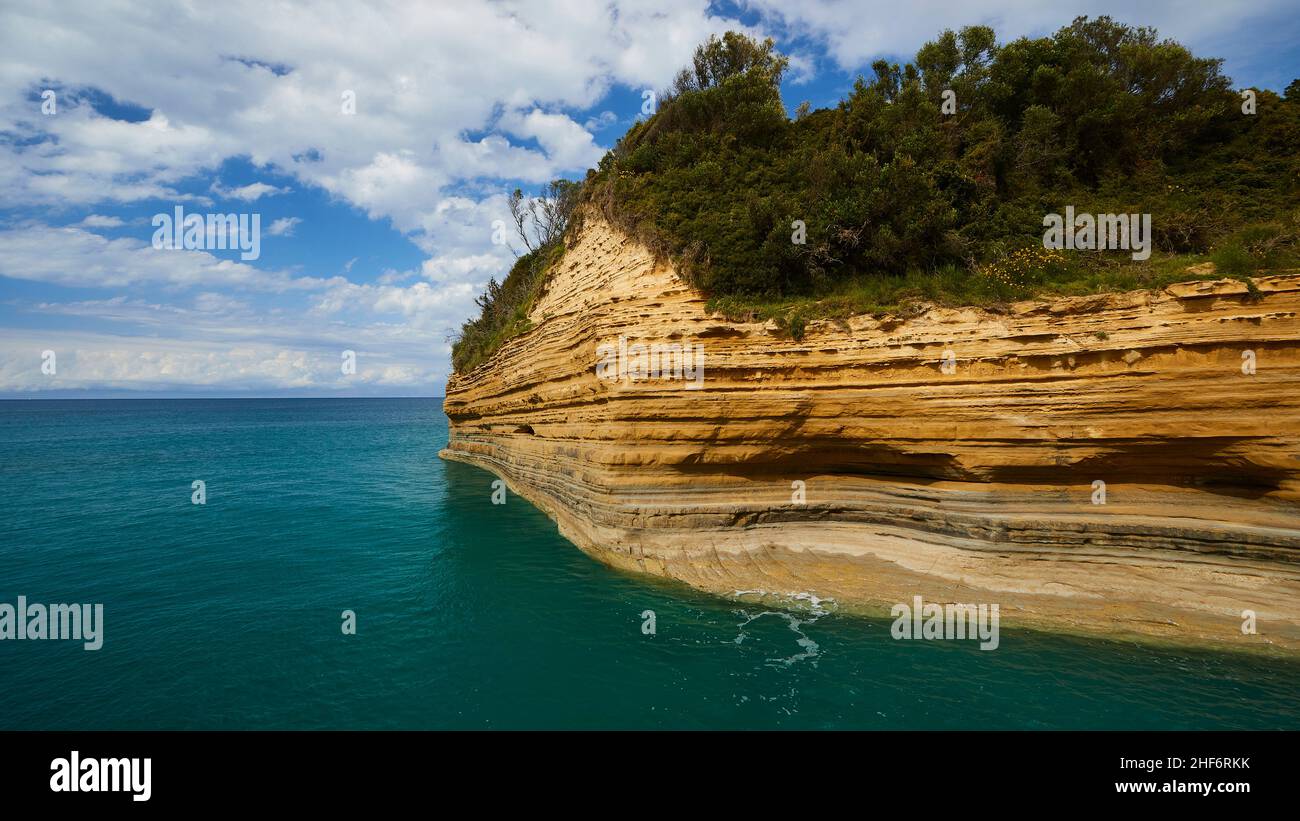 Grecia, Isole greche, Isole IONIE, Corfù, costa settentrionale, Bizzarre formazioni rocciose sulla costa, Canal d'amour, cielo blu, nuvole bianche, mare turchese, blu e verde, vista grandangolare, costa rocciosa con scanalature trasversali, verde mare, rocce soprastanti Foto Stock