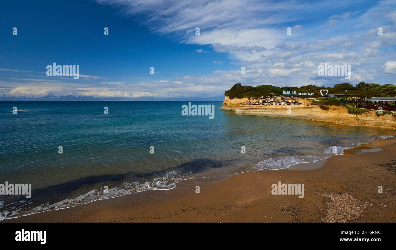 Grecia, Isole greche, Isole IONIE, Corfù, costa settentrionale, Bizzarre formazioni rocciose sulla costa, Canal d'amour, cielo blu, nuvole bianche, turchese, Mare blu e verde, in primo piano spiaggia sabbiosa e luce surf, sullo sfondo complesso spiaggia con grandi lettere pubblicitarie 'Canal d'amour' Foto Stock Grecia, Isole greche, Isole IONIE, Corfù, costa settentrionale, Bizzarre formazioni rocciose sulla costa, Canal d'amour, cielo blu, nuvole bianche, turchese, Mare blu e verde, in primo piano spiaggia sabbiosa e luce surf, sullo sfondo complesso spiaggia con grandi lettere pubblicitarie 'Canal d'amour' Foto Stock