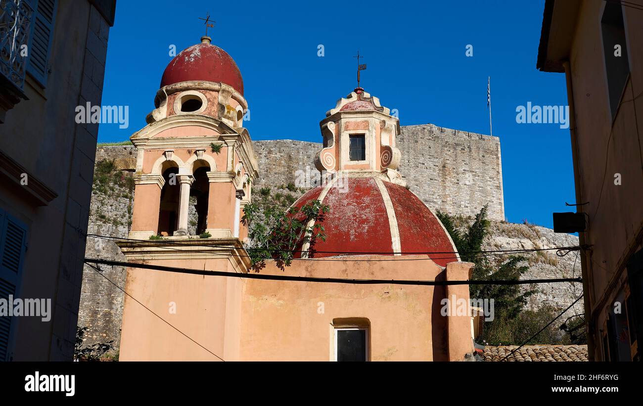 Grecia, Isole greche, Isole IONIE, Corfù, Corfù, Città vecchia, vista attraverso un vicolo fino alla Nuova Fortezza sullo sfondo, due torri rosse della chiesa a metà distanza Foto Stock