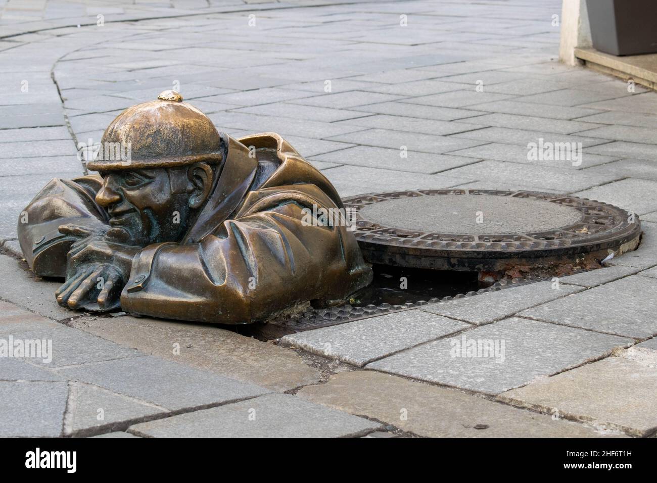 Cumil, la statua dell'uomo al lavoro, aka, l'Osservatore. Famosa scultura a Bratislava, Slovenia, raffigurante un operaio di fognature che sbucciava da un tombino al passo Foto Stock