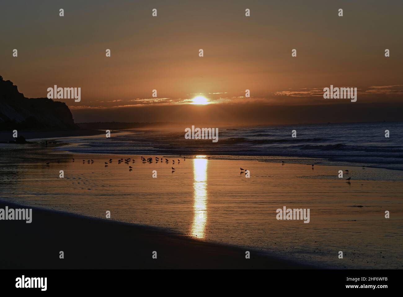 Alba sulla spiaggia di Albufeira, surf dell'Atlantico in controluce Foto Stock