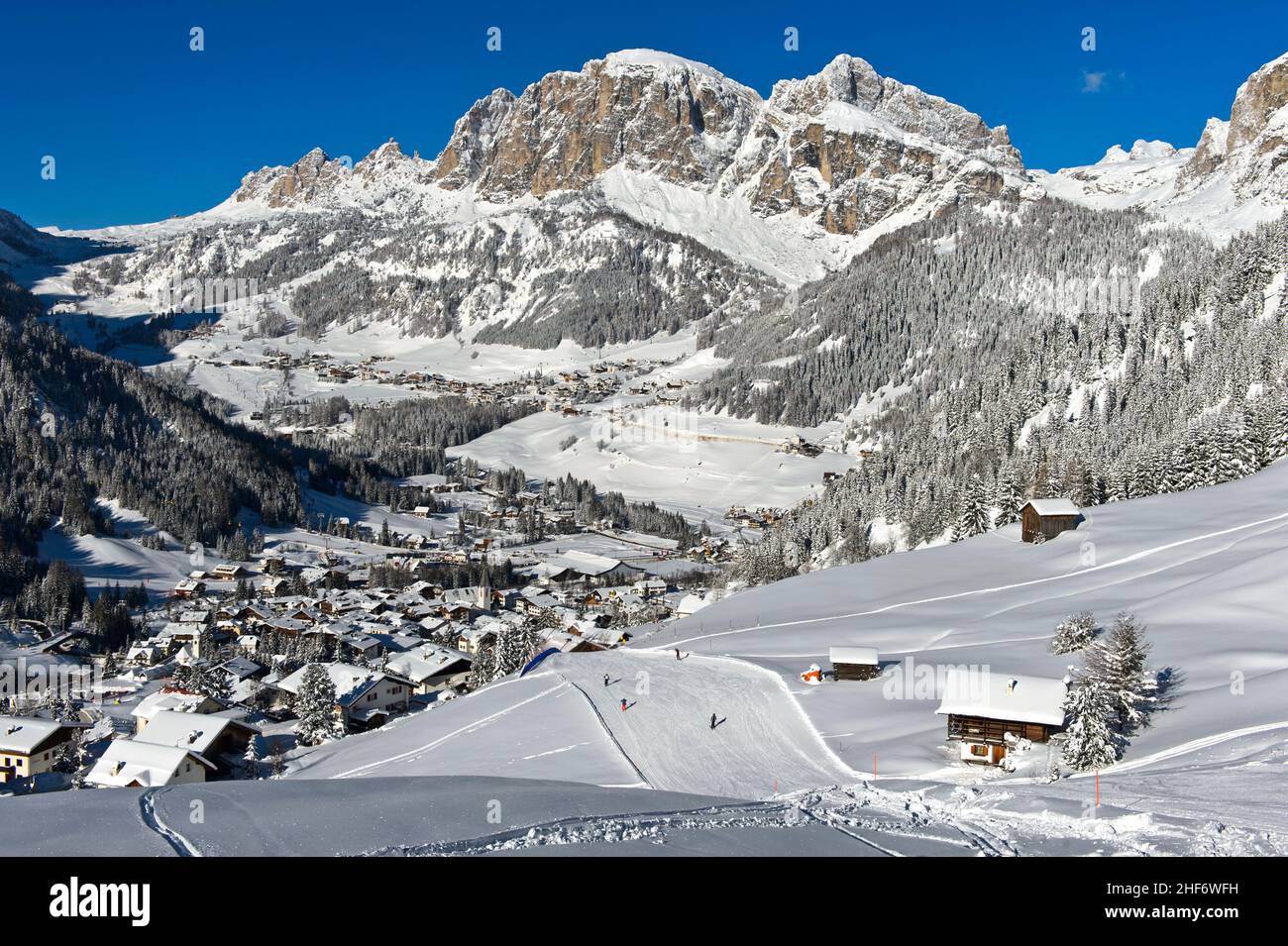 Piste sciistiche vuote nel villaggio montano di la Villa di fronte alle vette innevate del comprensorio sciistico dell'alta Badia, Dolomiti, Alto Adige, Italia Foto Stock