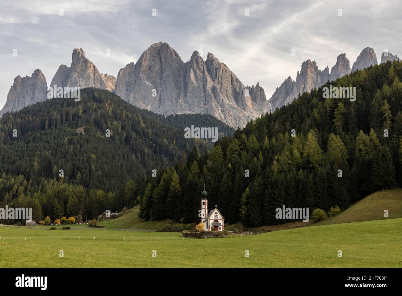 La chiesa di San Giovanni a Villnösstal al tramonto con il gruppo Geissler sullo sfondo. Foto Stock