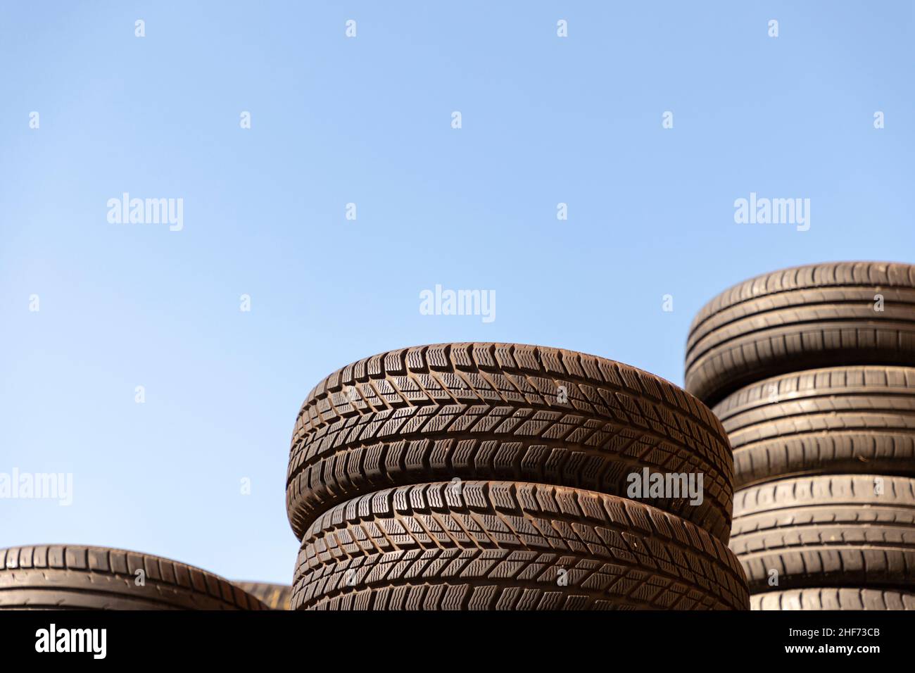 rifiuti impilati vecchi pneumatici contro il cielo blu Foto Stock