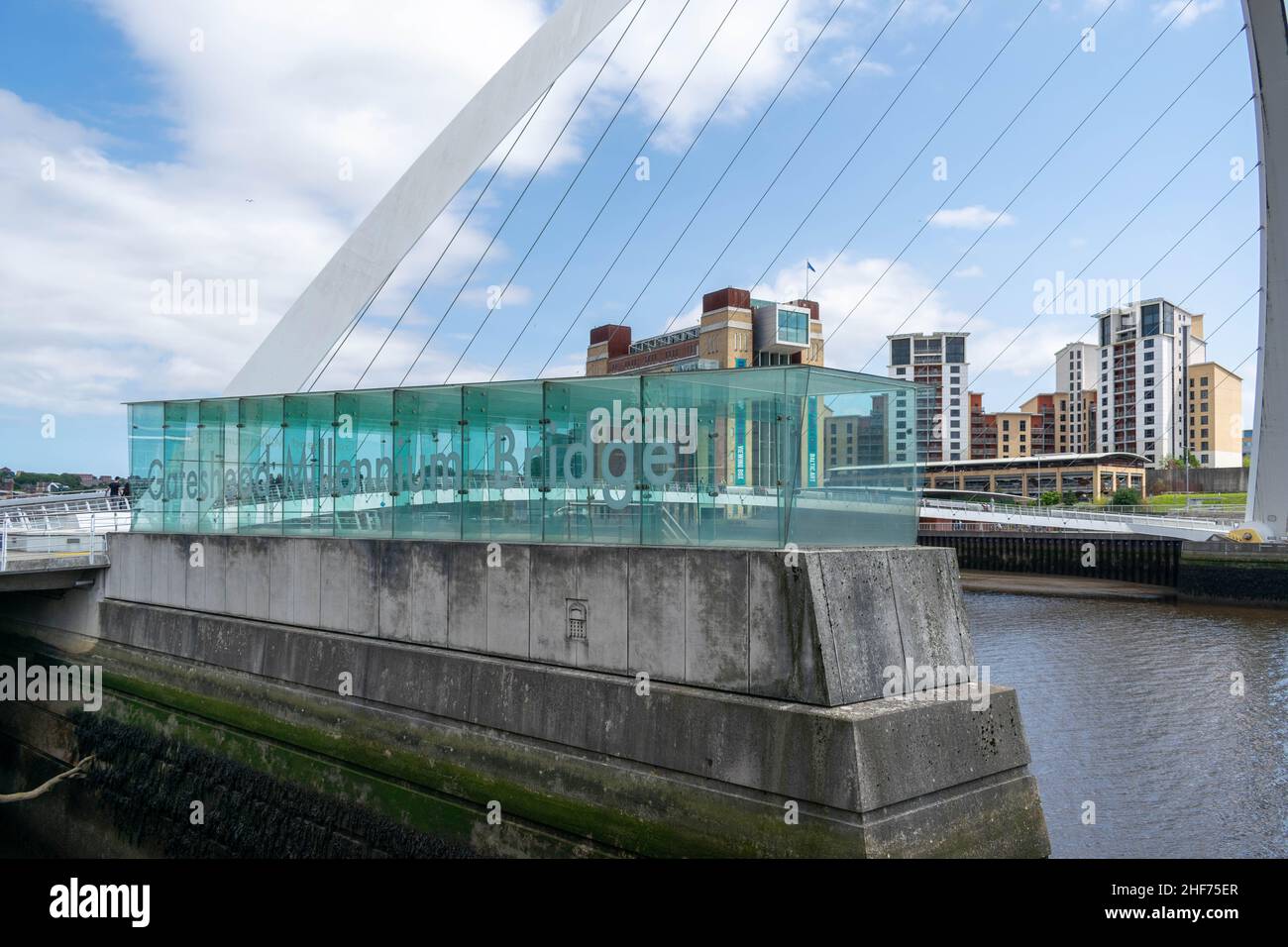 Newcastle, UK - 7 maggio 2019: Gateshead Millennium Bridge è un ponte pedonale e ciclista che attraversa il fiume Tyne. I mulini di farina del Baltico derelict b Foto Stock