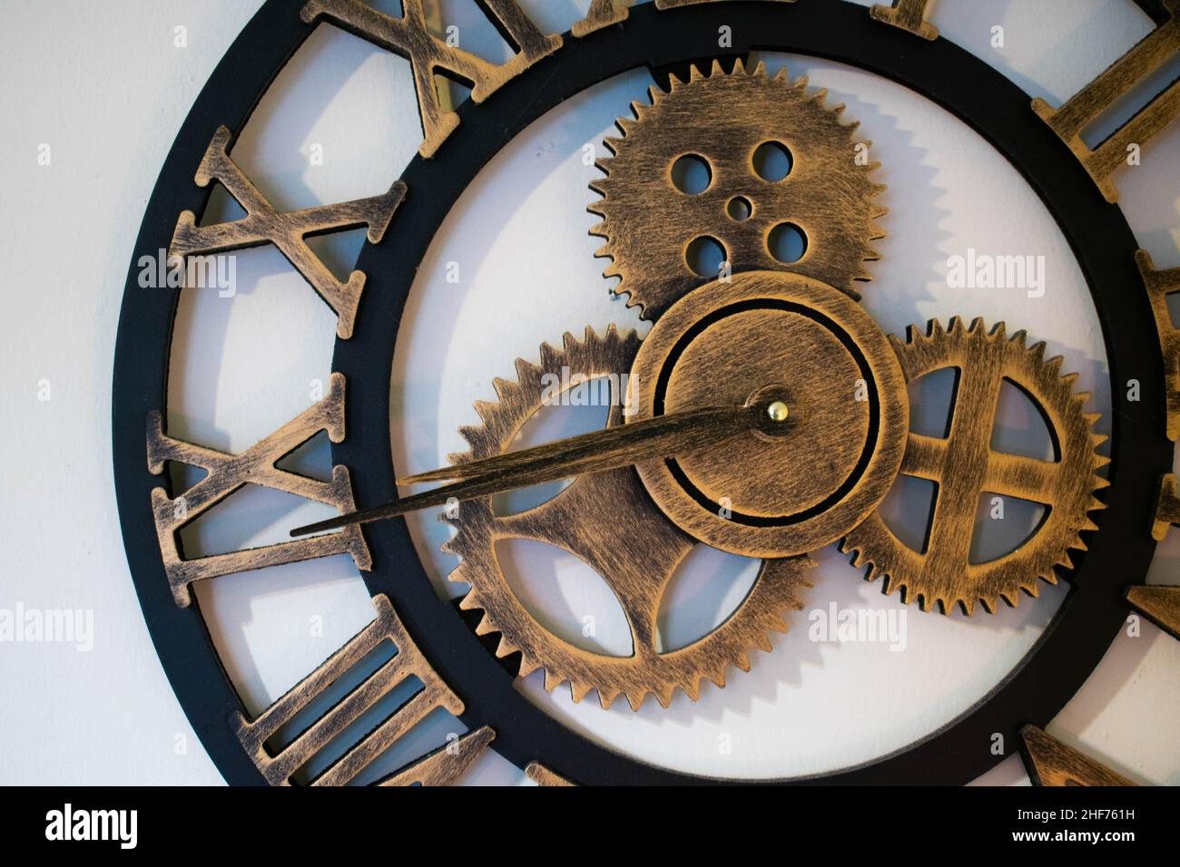 Grande orologio da parete industriale in rame e ottone. Tali orologi si aprono mostrando gli elementi interni delle lavorazioni degli orologi, quali le spine e i rivetti. Foto Stock