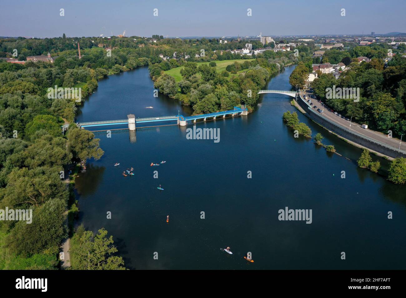 Muelheim an der Ruhr, Renania settentrionale-Vestfalia, Germania - Saarn-Mendener Ruhraue, zona verde della Ruhr a Muelheim an der Ruhr. Pedalatori in piedi davanti al Muelheim an der Ruhr weir. Centro dell'isola della Ruhr. Nella parte posteriore destra la città. Nella parte posteriore sinistra si trova il Museo della pelle e dell'abbronzatura. Foto Stock